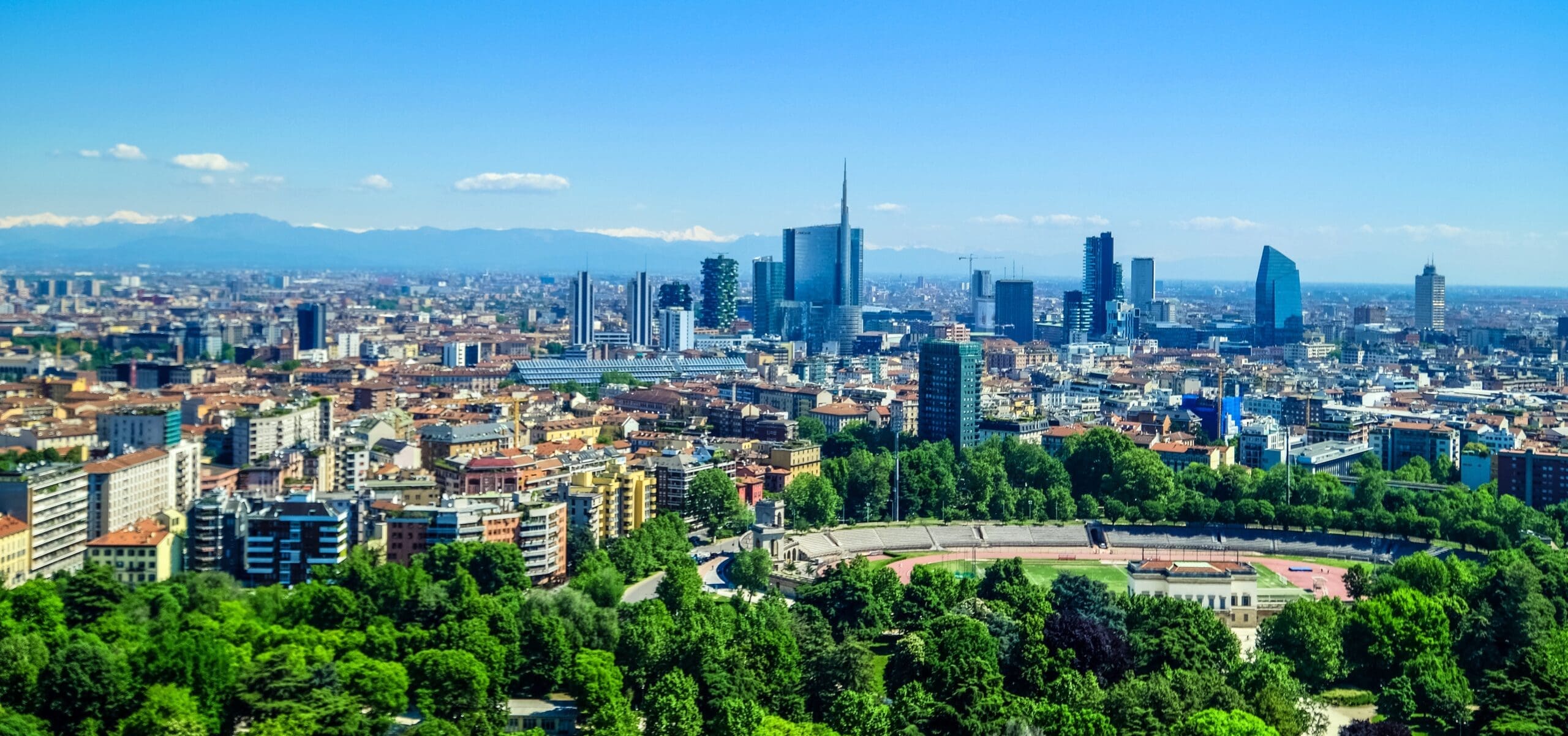 Stadtbild von Mailand: im Hintergrund die Alpen, in der Mitte der Unicredit Tower (das höchste Gebäude Italiens); im Vordergrund sind Teile des Parco Sempione zu sehen