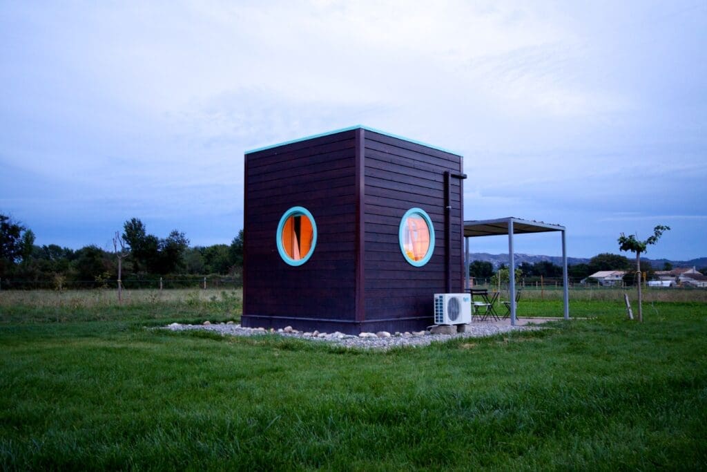 "Carré d’étoiles" ("star box") in France: A portable cube-shaped black vacation cabin with porthole windows, designed with a skylight in the roof for stargazing