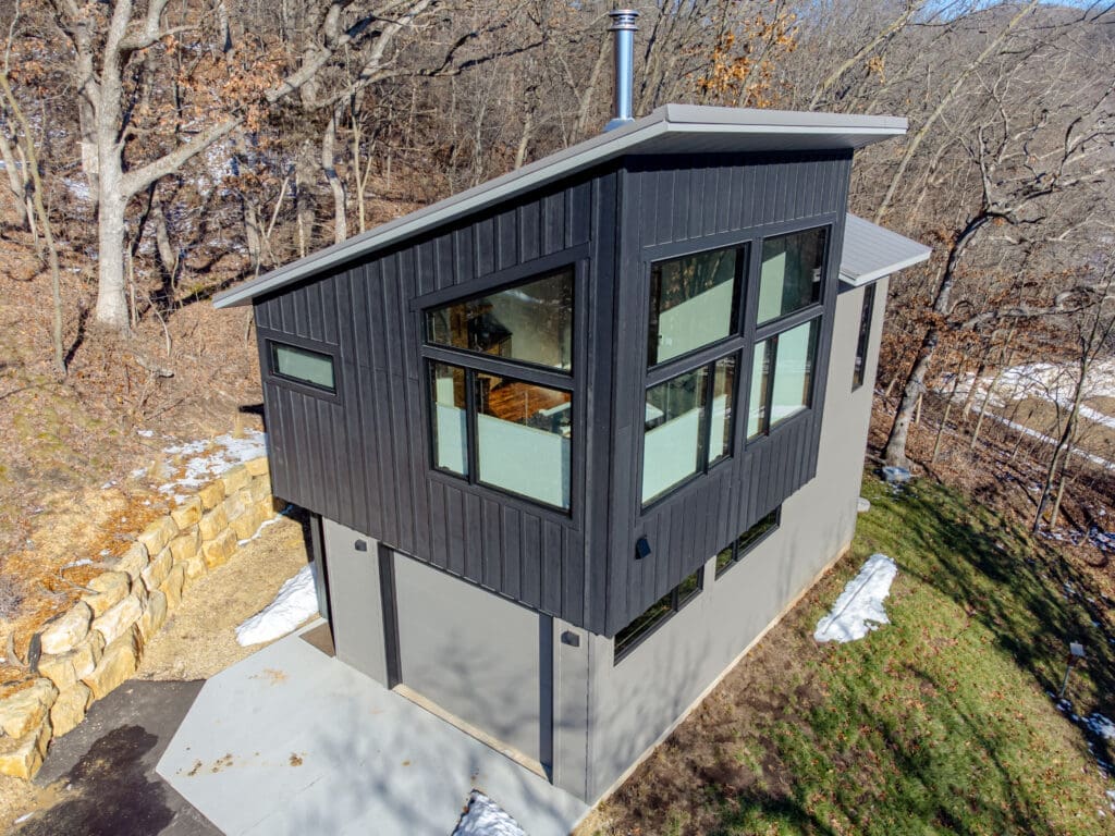 A two-story tiny home with a garage on the ground floor