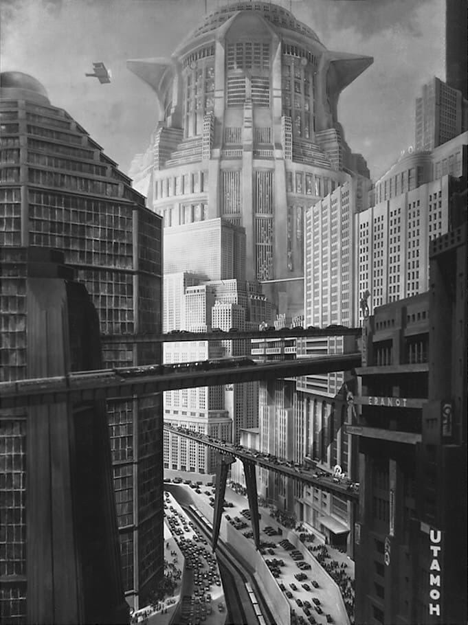 Epic scene of the rich, capitalistic upper city, with visionary transport and tall glittering towers; half a century later this scene inspired Blade Runner's dystopian Los Angeles