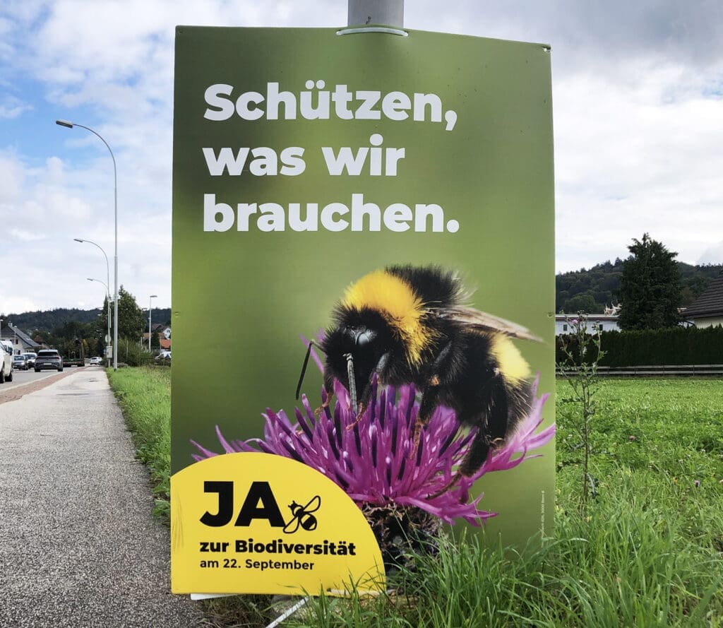 Election poster featuring a photo of a bumblebee perched on a clover blossom, created for a Swiss referendum