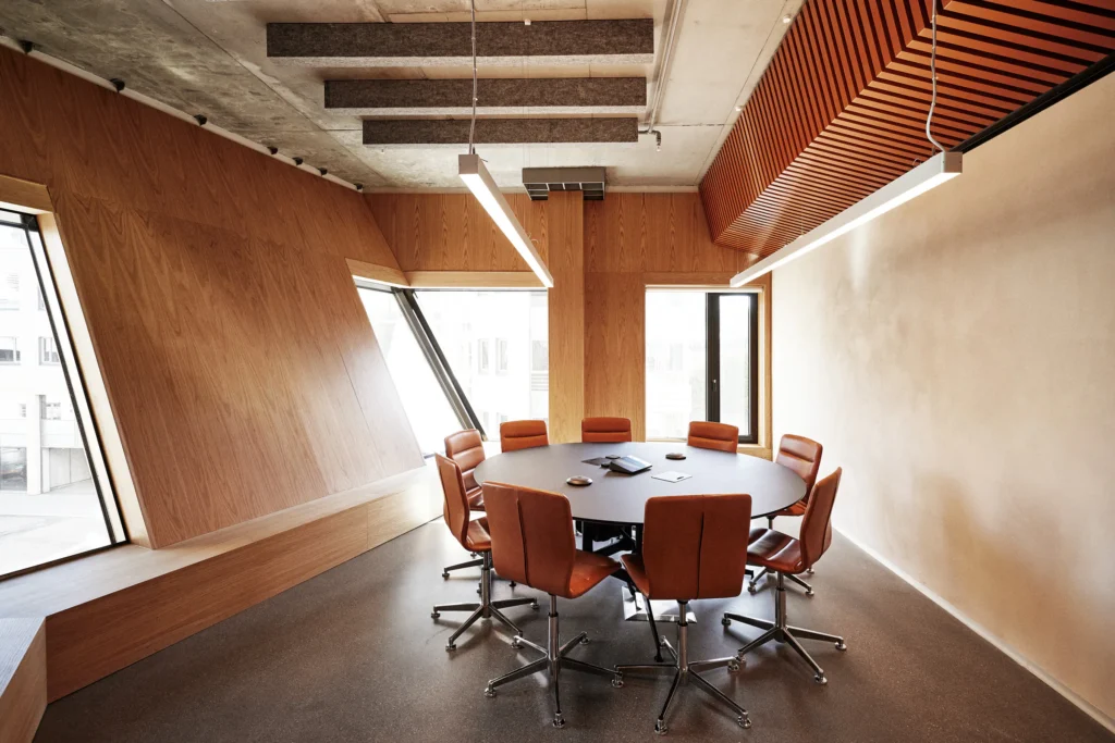 Meeting room with a round table and red chairs